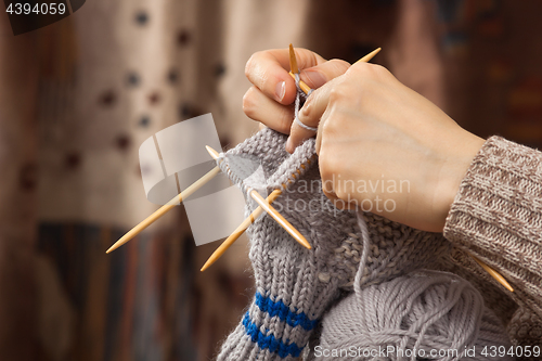 Image of hands of woman knitting a sock
