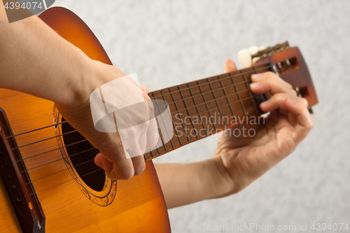 Image of hands playing acoustic guitar