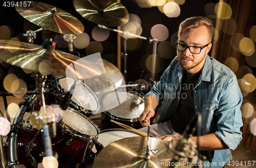 Image of male musician playing drums and cymbals at concert