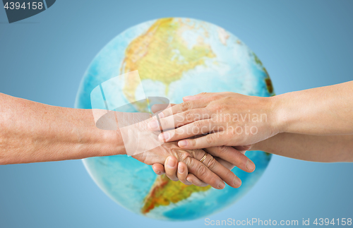 Image of close up of senior and young woman holding hands