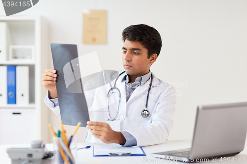 Image of doctor looking at spine x-ray scan at clinic