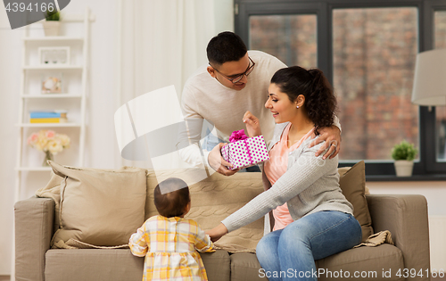 Image of happy family with birthday present at home