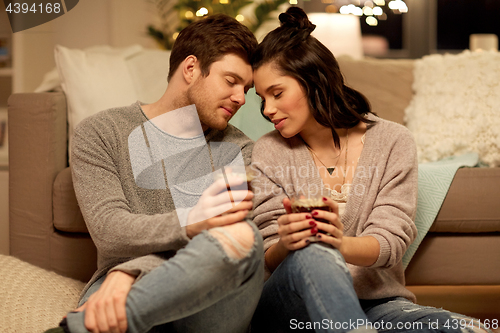 Image of happy couple drinking coffee and eating at home