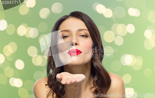 Image of beautiful woman with red lipstick blowing air kiss