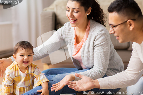 Image of happy family with baby daughter at home