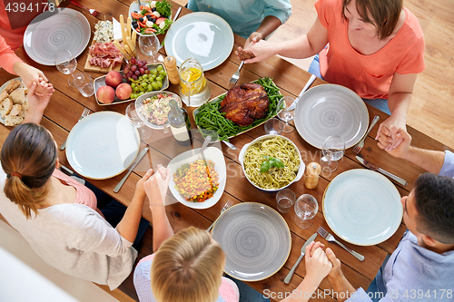 Image of group of people at table praying before meal