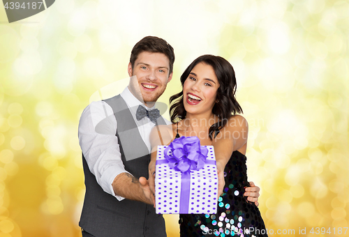 Image of happy couple with gift box at birthday party