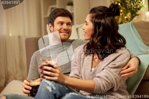 Image of happy couple drinking coffee and eating at home