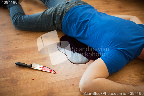 Image of dead man body lying on floor at crime scene