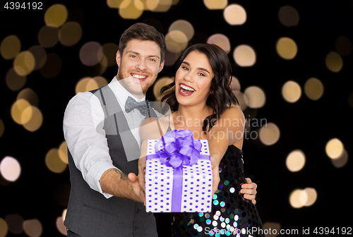 Image of happy couple with gift box at birthday party