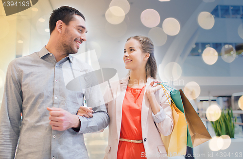 Image of happy young couple with shopping bags in mall