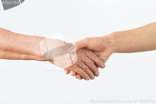 Image of close up of senior and young woman holding hands