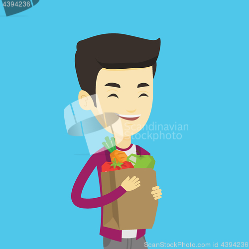 Image of Happy man holding grocery shopping bag.