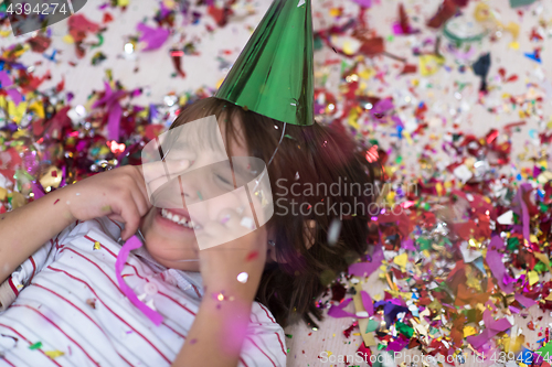 Image of kid blowing confetti while lying on the floor