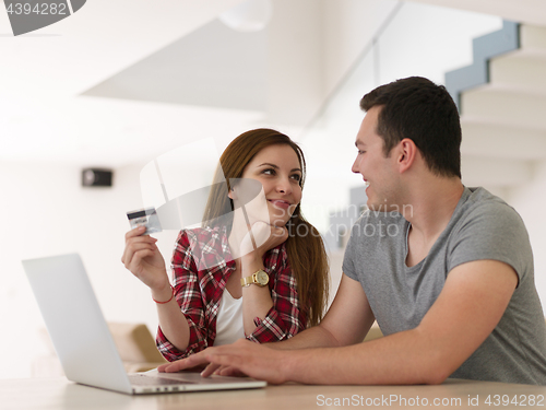 Image of happy young couple buying online