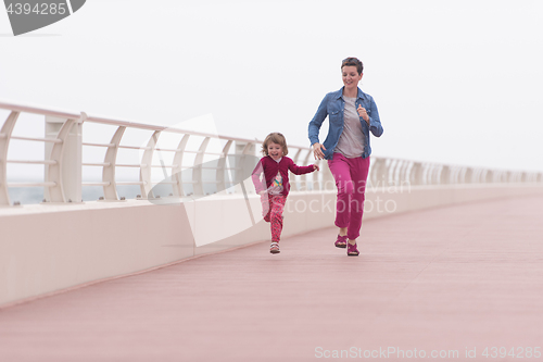 Image of mother and cute little girl on the promenade by the sea