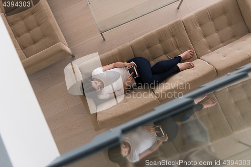 Image of woman on sofa using tablet computer