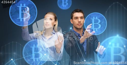 Image of businessman and businesswoman with bitcoins