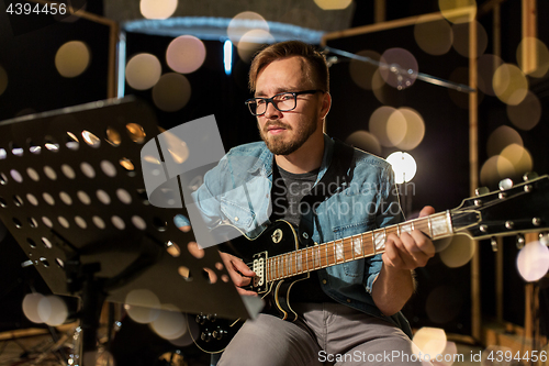 Image of man playing guitar at studio rehearsal