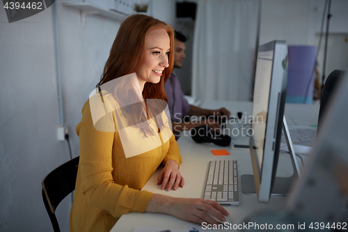 Image of happy woman with computer working at office