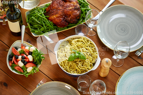 Image of pasta, vegetable salad and other food on table