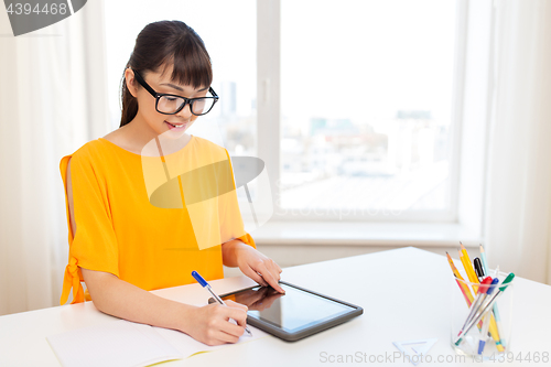 Image of asian student girl with tablet pc learning at home