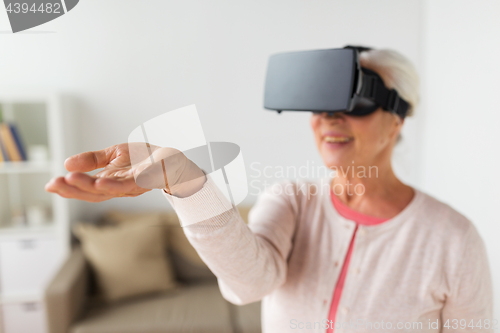 Image of old woman in virtual reality headset or 3d glasses