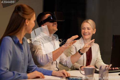 Image of business team with computer working late at office