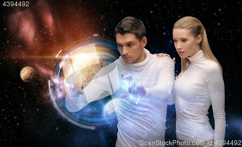 Image of couple with planet hologram over space background