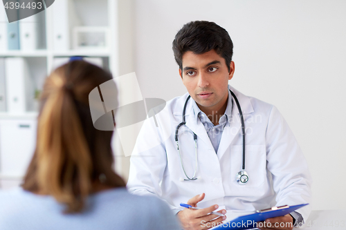 Image of doctor with clipboard and patient at hospital