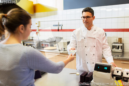 Image of seller and customer paying at fast food restaurant