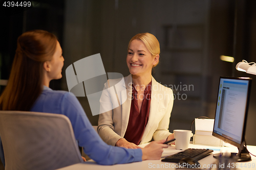 Image of businesswomen talking late at night office