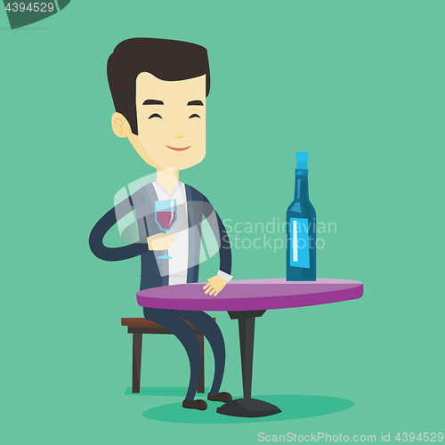 Image of Man drinking wine at restaurant.