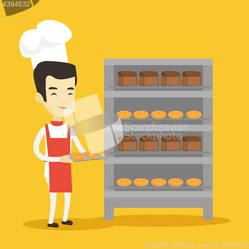 Image of Happy young male baker holding tray of bread.