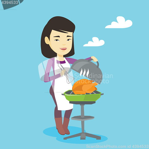 Image of Woman cooking chicken on barbecue grill.