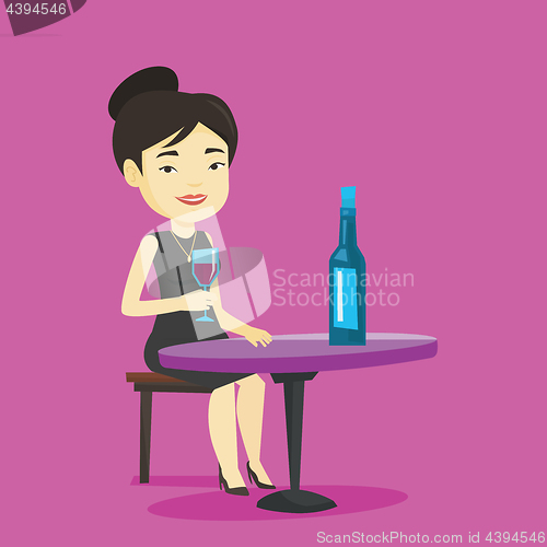 Image of Woman drinking wine at restaurant.