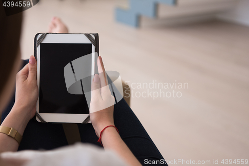 Image of woman sitting on sofa with tablet computer