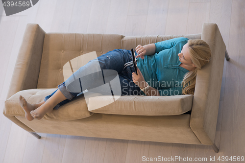 Image of woman on sofa using tablet computer