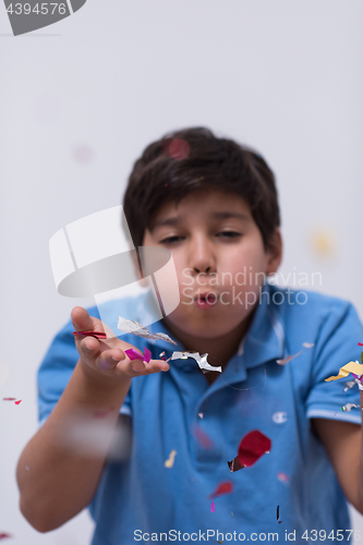 Image of kid blowing confetti