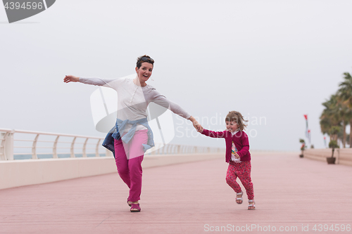 Image of mother and cute little girl on the promenade by the sea