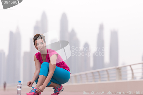 Image of woman tying shoelaces on sneakers