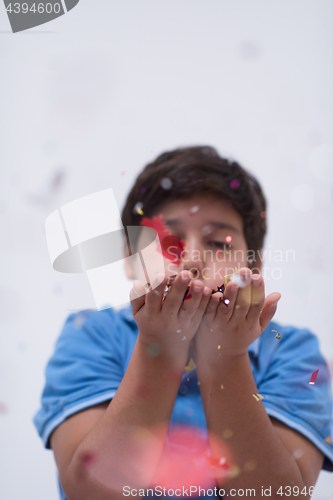 Image of kid blowing confetti