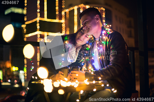 Image of Young couple kissing and hugging outdoor in night street at christmas time