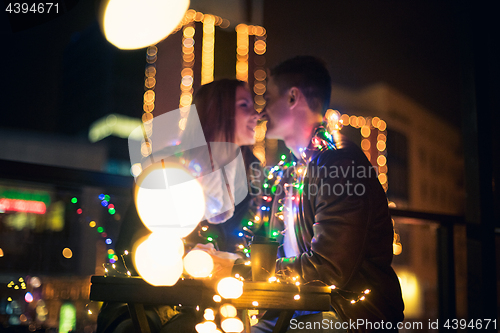 Image of Young couple kissing and hugging outdoor in night street at christmas time