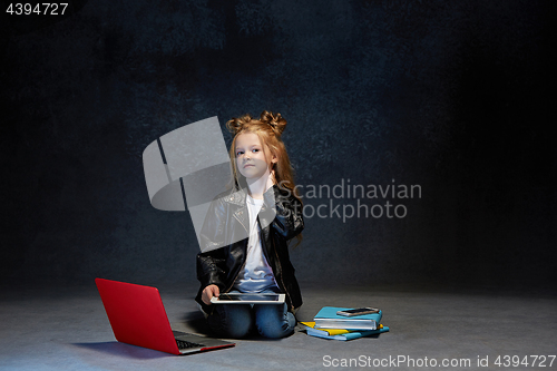 Image of Little girl sitting with gadgets