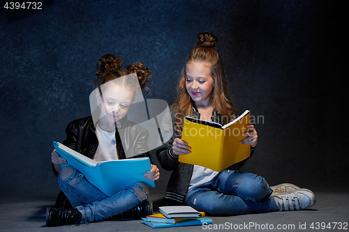 Image of Two kids reading the books at studio
