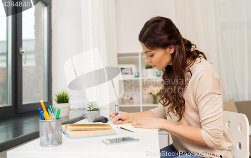 Image of female student with book learning at home