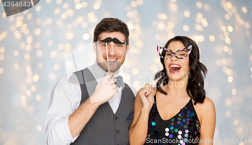 Image of happy couple with party props having fun