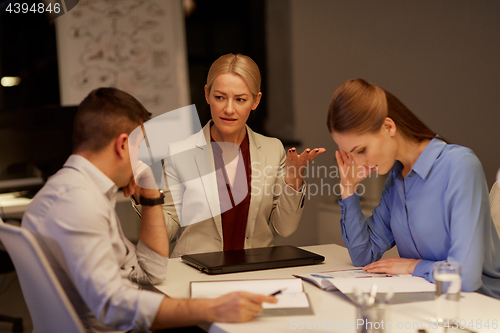 Image of business team with laptop working late at office