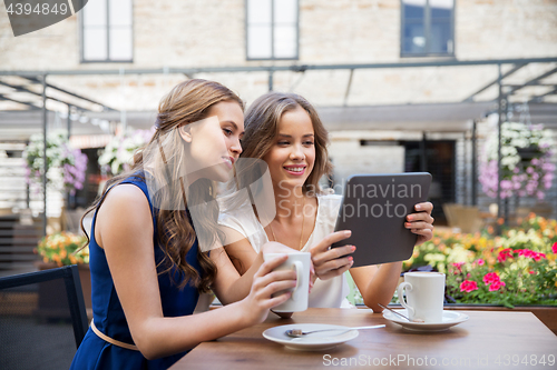 Image of young women with tablet pc drinking coffee at cafe